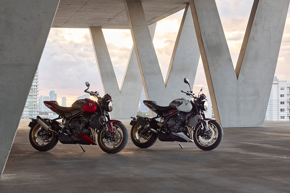 Two Trident 800s, in Ash Grey and Carnival Red, staged on a concrete patio.