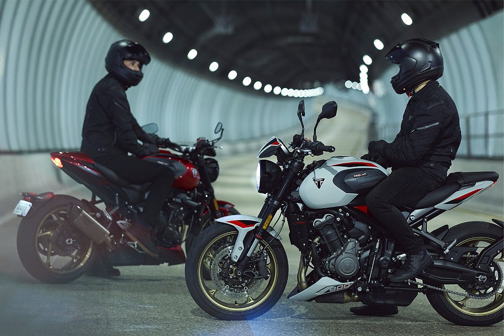 Two riders mounted on separate Trident 800s inside an urban tunnel.