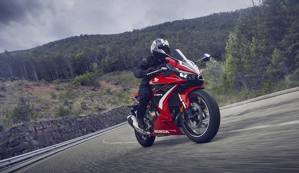 rider on a red Honda CBR500R on a mountain road