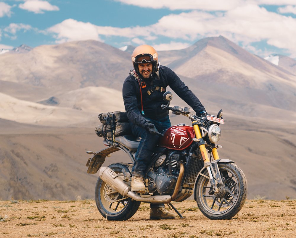Spurgeon smiling while on a Triumph Speed 400 high in the mountains of India