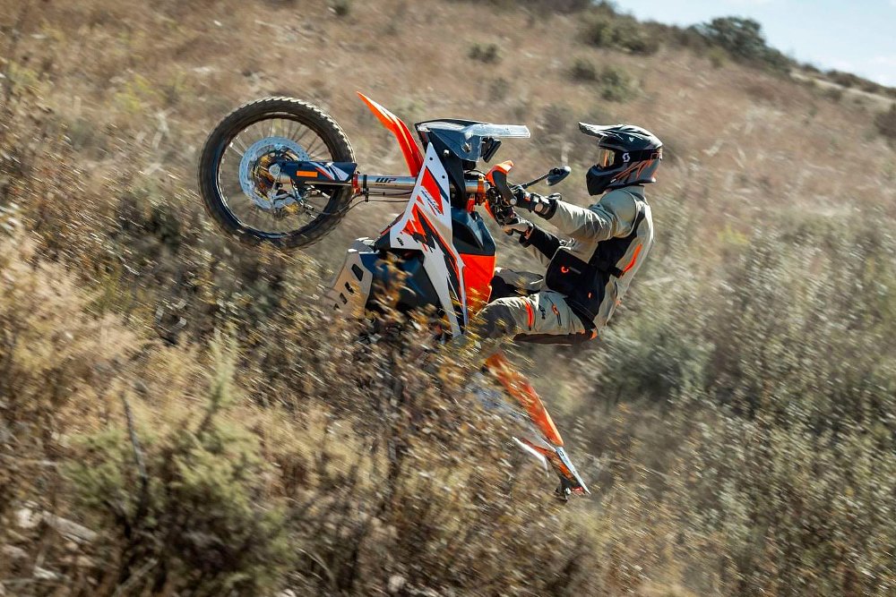 An 890 Adventure R rider hucks a wheelie off-road.