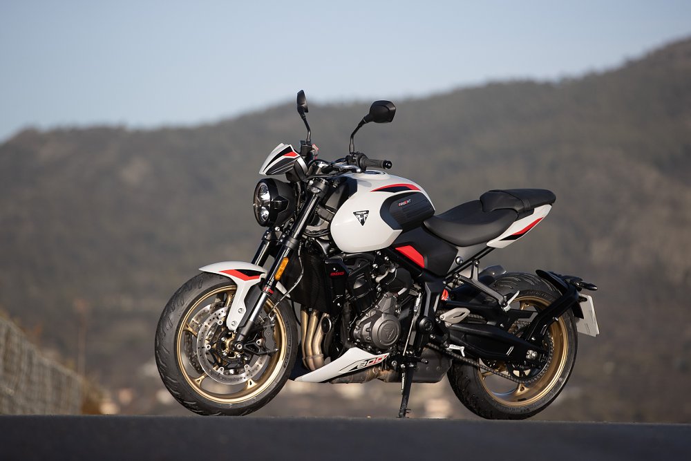 the Trident 800 parked on a country road in Cyprus, mountains in the distant background