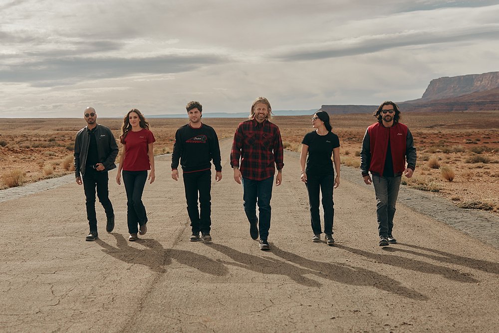 Six models dressed in Indian's 125th Anniversary apparel collection walk toward the camera.