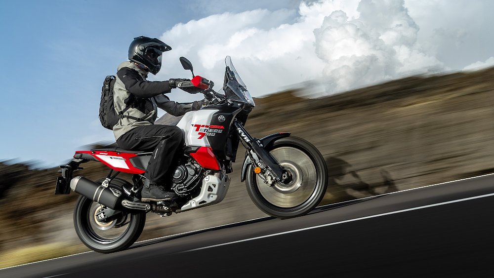 A rider guides the Ténéré 700 World Raid up a paved hill.