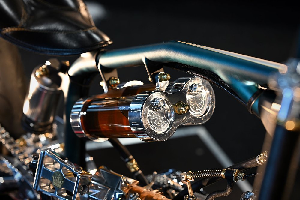 close view of two tubular glass oil tanks suspended from the motorcycle's frame
