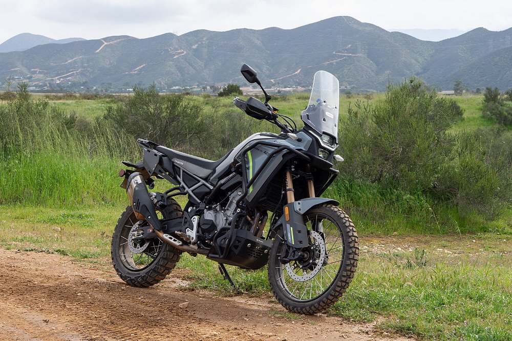 The Ibex 450 pictured trailside with a mountain range in the background.
