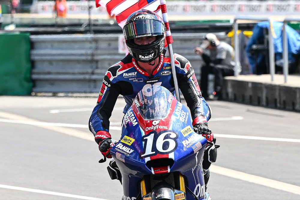 Joe Roberts carries the U.S. flag as he rides to victory lane.