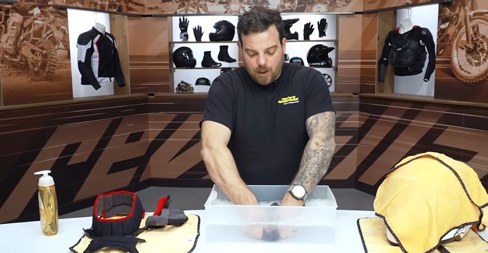 Pat washing the interior parts of the helmet by hand in a pan of warm, slightly soapy water