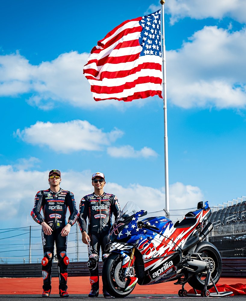 Bezzecchi and Mart&iacute;n posing with the X 250th at COTA under the huge U.S. flag