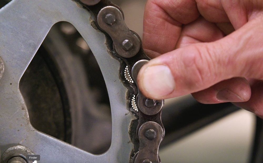 Motorcycle chain showing excessive wear at rear sprocket