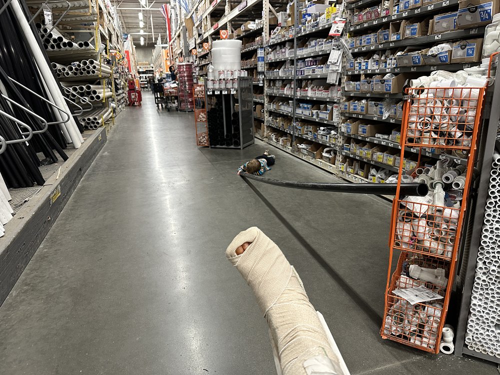 An aisle at Home Depot, shown from the perspective of someone in a wheelchair with a cast on their leg.