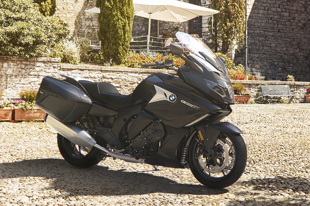A BMW K 1600 GT parked in a sunny courtyard.