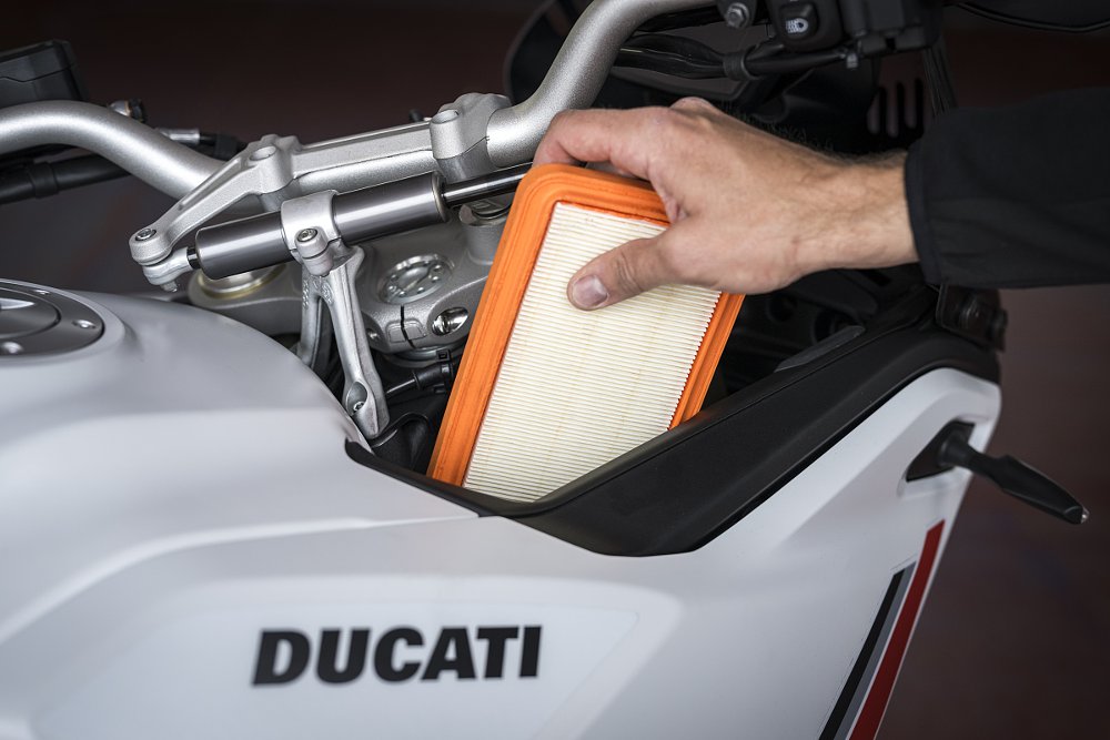 view of the air filter being pulled from a slot by the fuel tank