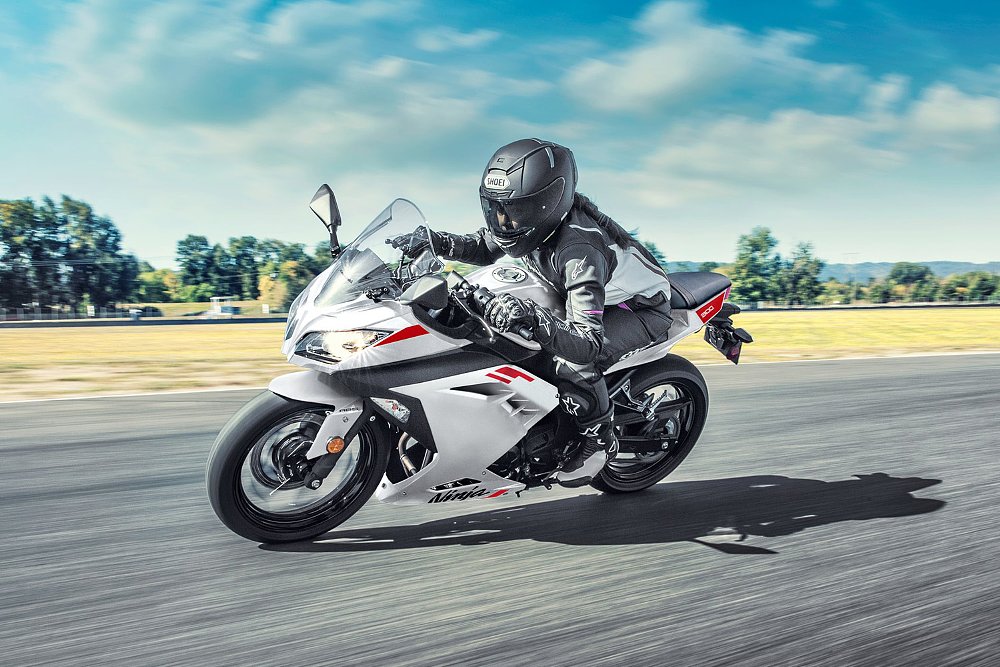 A female rider steers the Ninja 300 through a turn on the race track.