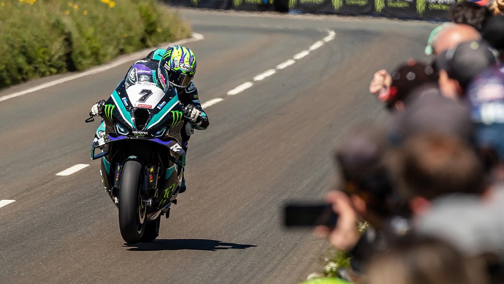 A rider blasts past a spectating area at the Isle of Man TT.