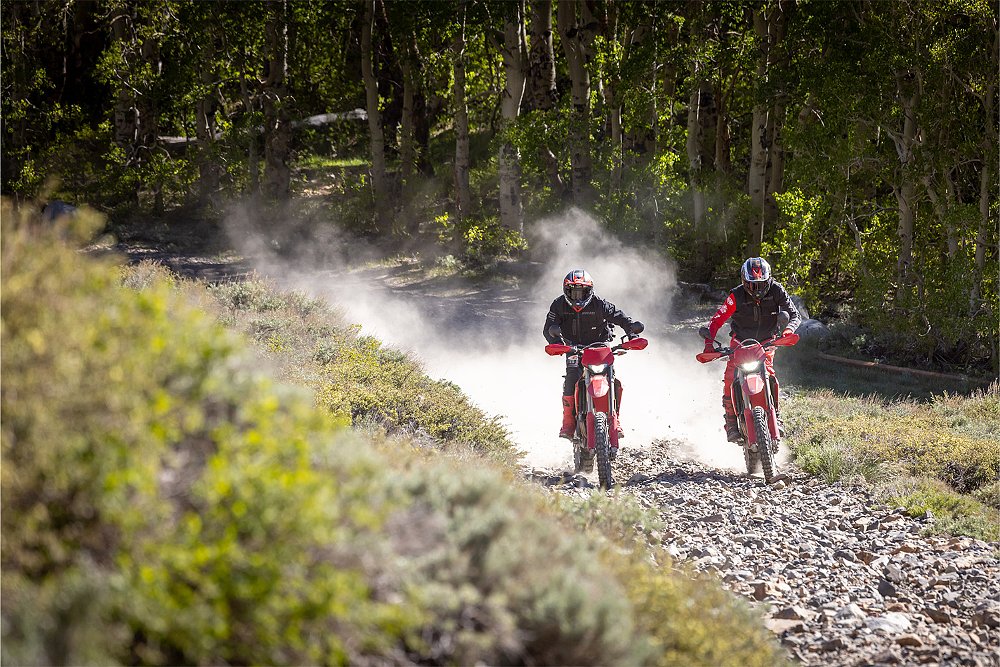 Two Desmo450 EDS rider tractor up a rocky off-road trail.