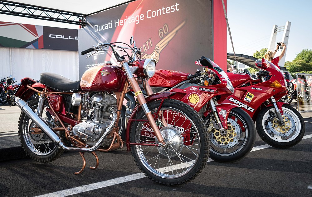 three vintage Ducati motorcycles from different eras on display on stage