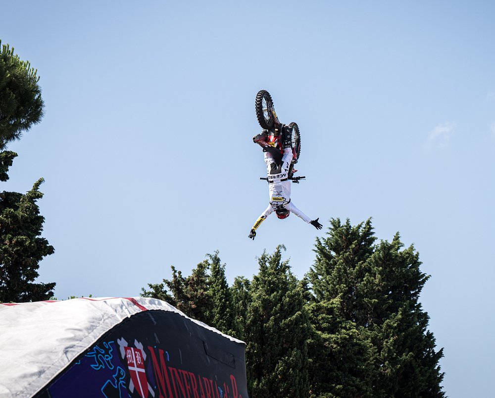 rider doing a backflip high in the air on a Ducati motocross bike
