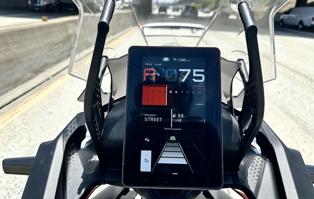 2027 KTM 1390 Super Adventure S EVO TFT dash detail showing adaptive cruise control engaged on a highway.