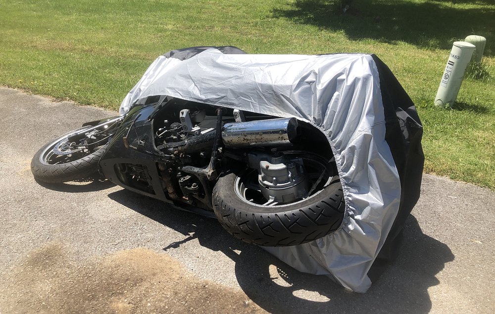 Motorcycle lying on its side in the driveway