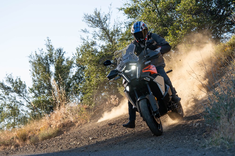 KTM's 1390 Super Adventure S EVO kicking up dust on a dirt embankment.