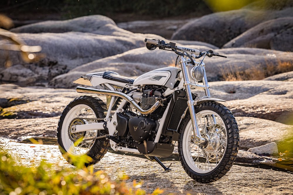 white and silver scrambler-style motorcycle parked on large rocks