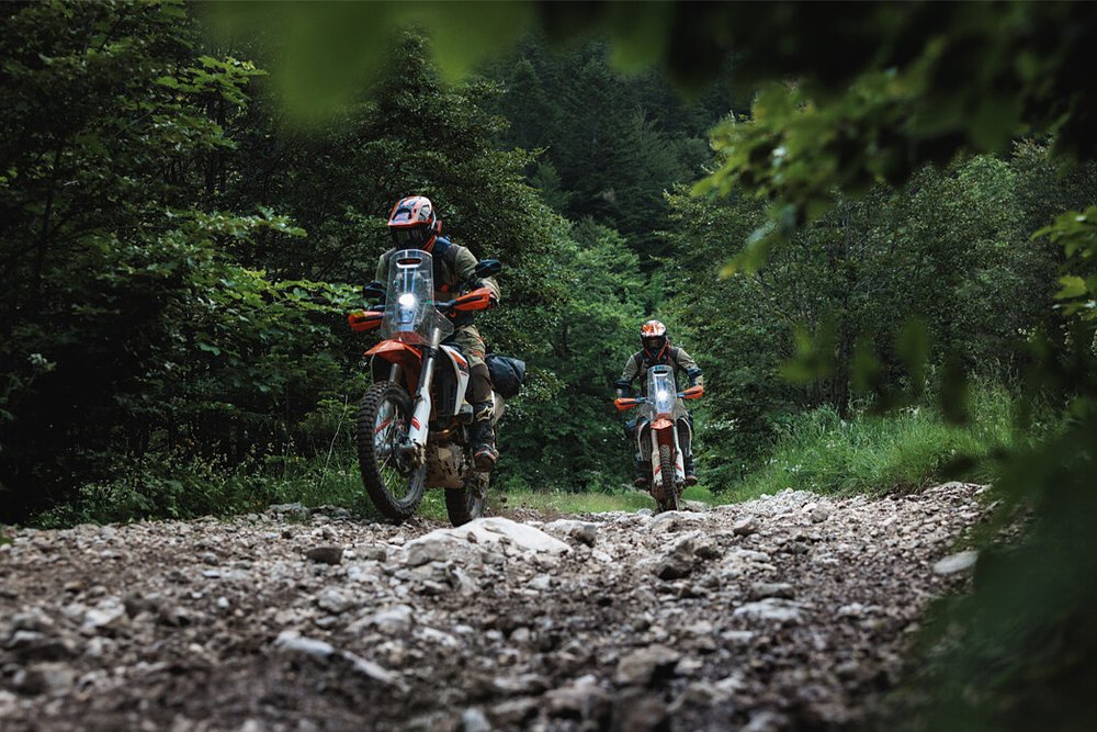 A pair of off-road riders pick through a rock garden on the 690 Rally.