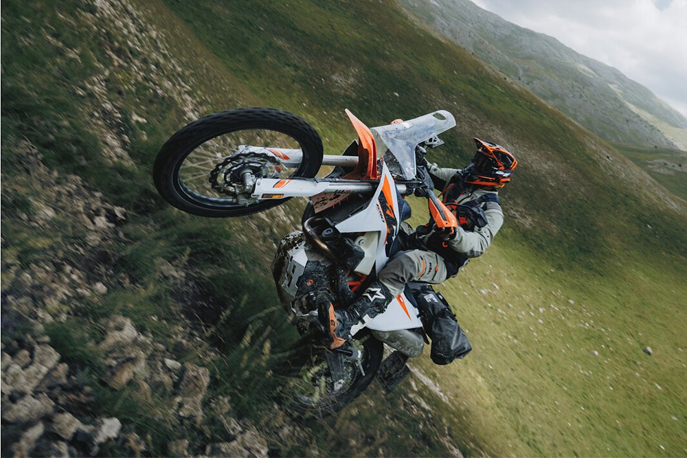 A 690 Rally rider climbs a steep hill.