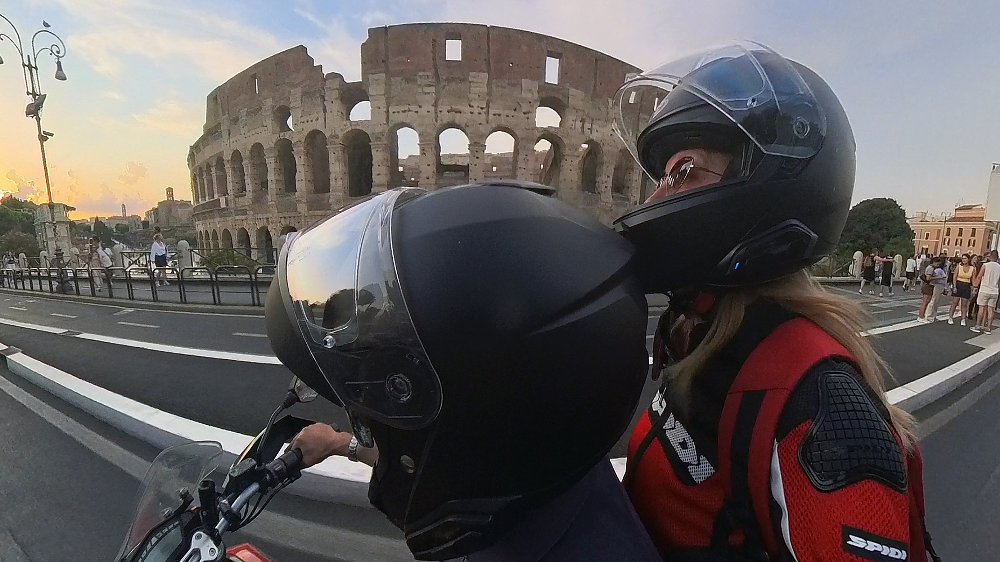 selfie of the two riding past the Colosseo in Rome