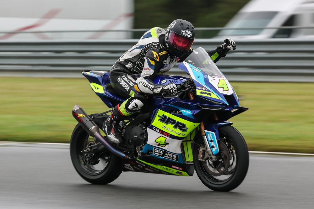 Josh Hayes on his Yamaha raises a fist to celebrate a victory in a rainy race