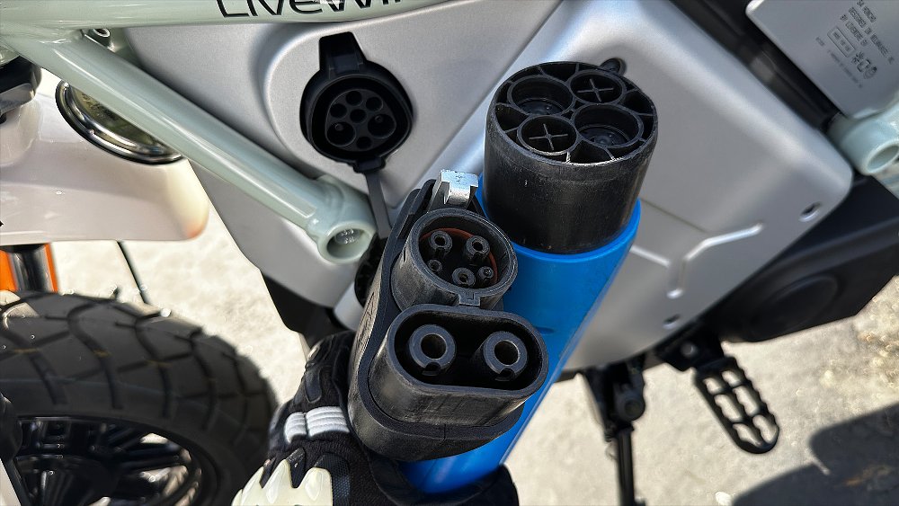 Dustin holds a CCS and CHAdeMO charging connector next to the Honcho's Type 6 connector.