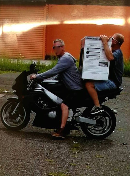 Two men steal an aquarium with a motorcycle.