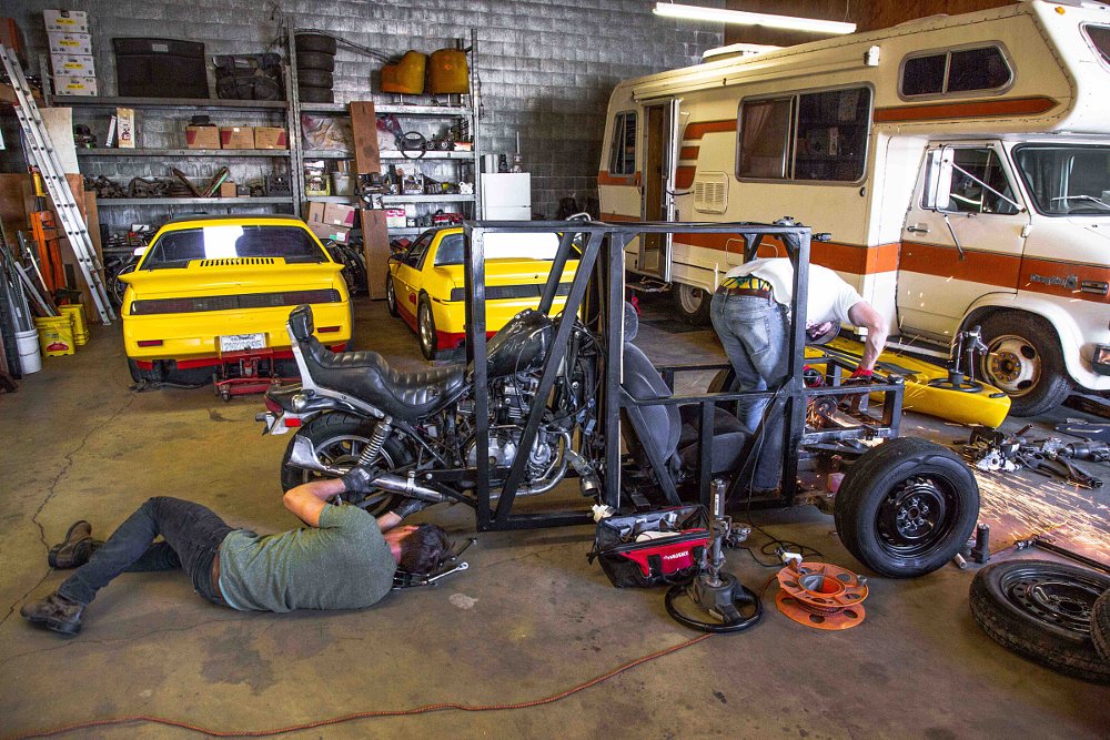 working on the three-wheeler in the shop