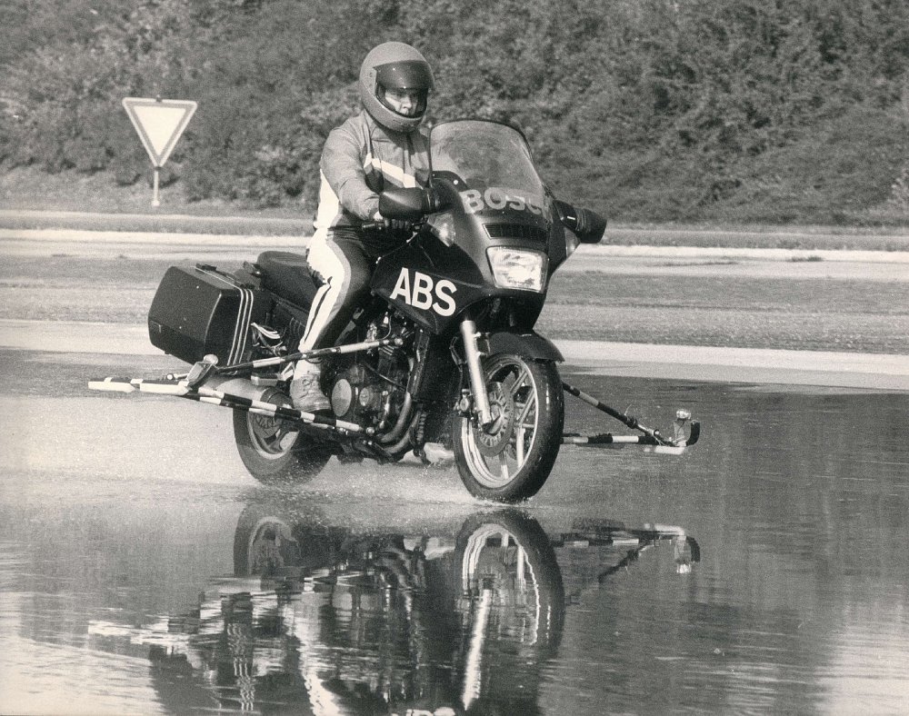 black and white photo of motorcycle ABS test on wet pavement