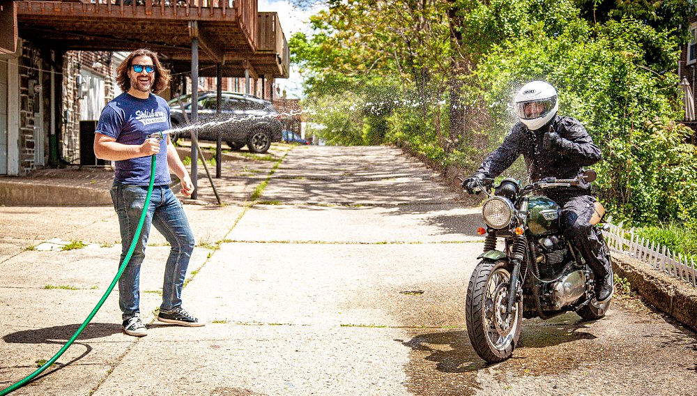 Spurgeon Sprays Brandon With A Water Hose To Showcase Waterproof Gear And He Loves It