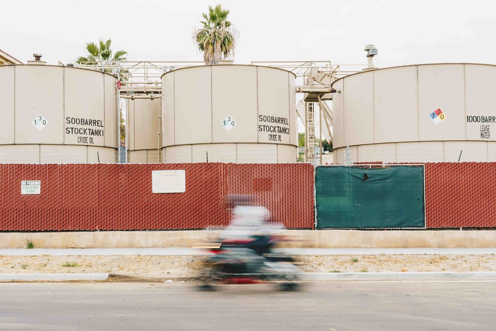 Crude oil tanks in Long Beach CA with blurred motorcycle