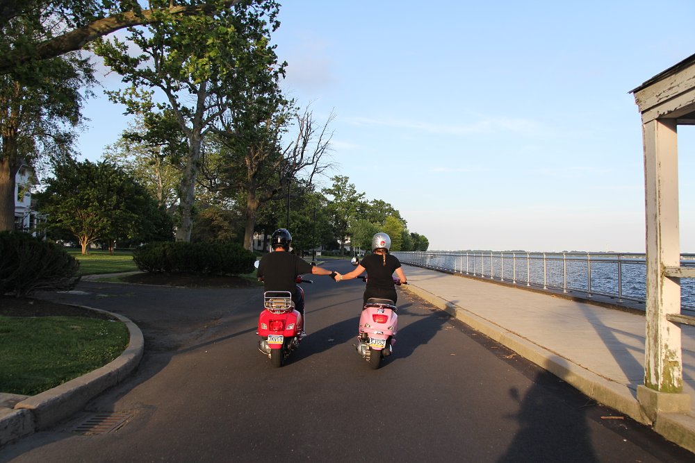 Scooter riders holding hands