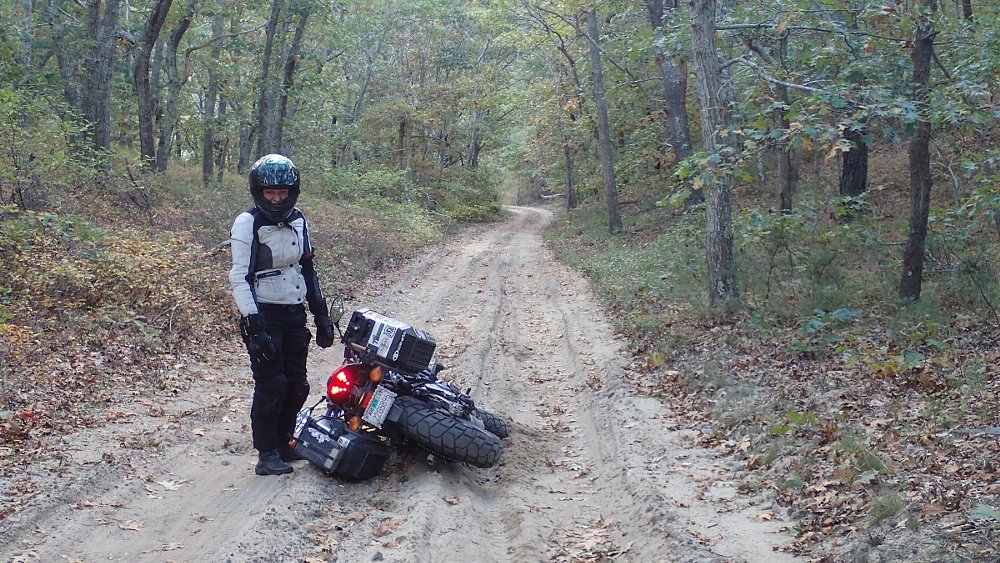 tipped over motorcycle on a sand road