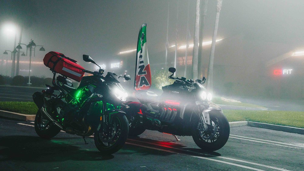 Kawasaki Z H2 and Triumph Rocket 3 sitting in foggy parking lot