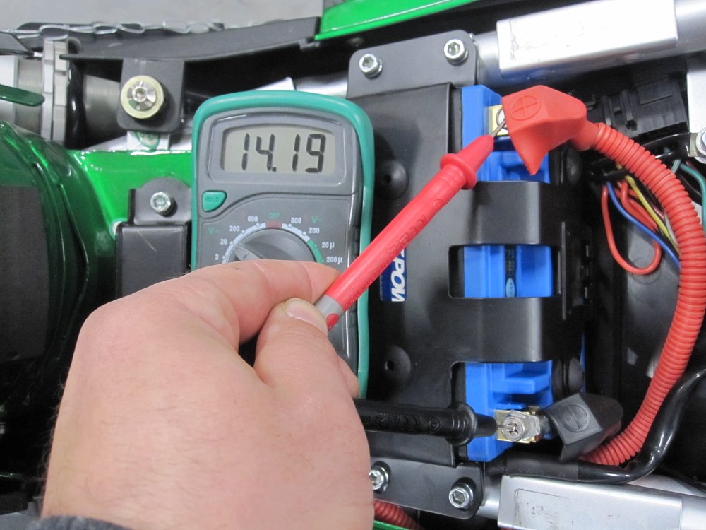 Checking the charge rate of a motorcycle battery while it is running.