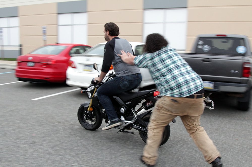 Having a friend help push you to bump start a motorcycle