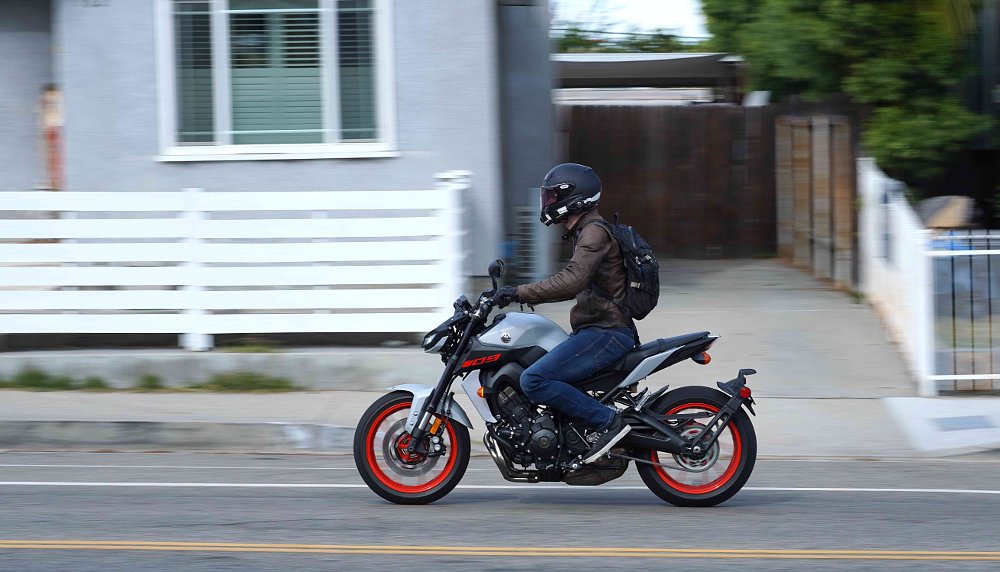 A profile of the left side of a Yamaha MT-09 riding on a city street.