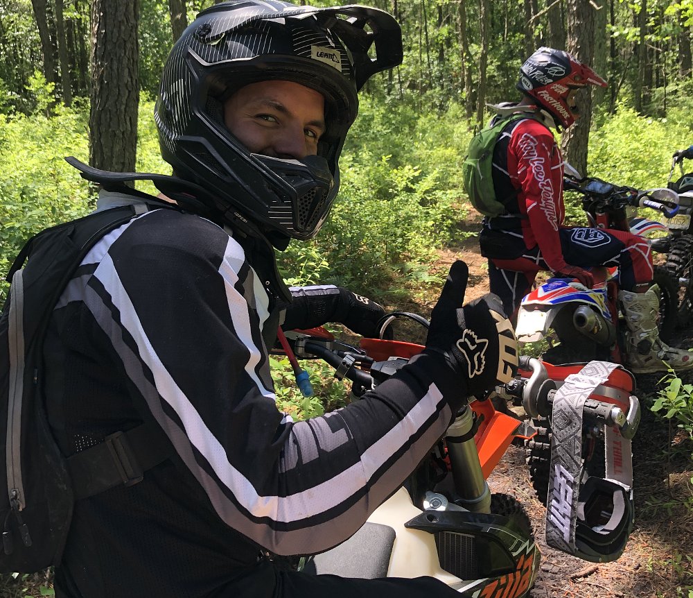 Ride with friends. Dirt biker riding with friends on trails in the woods.