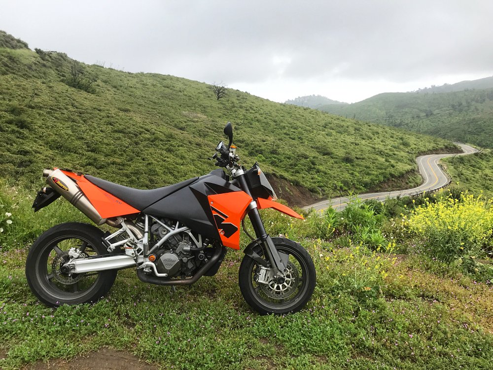 2006 KTM 950 SM with a twisty road in the background