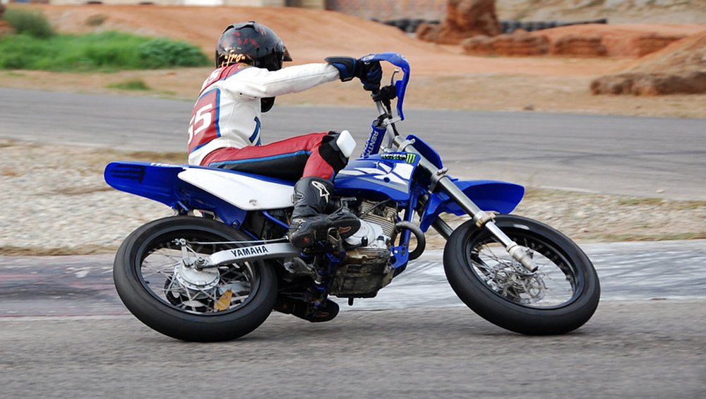 Jen rides the TT-R 125 on the go kart track leaned over in a corner