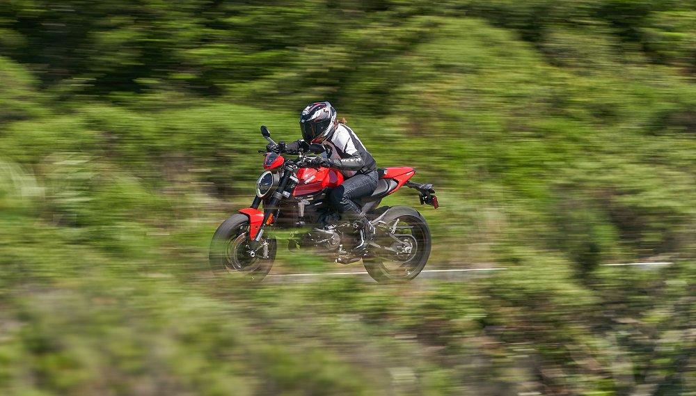 A female rider is a fast blur in a straight line on the Ducati Monster