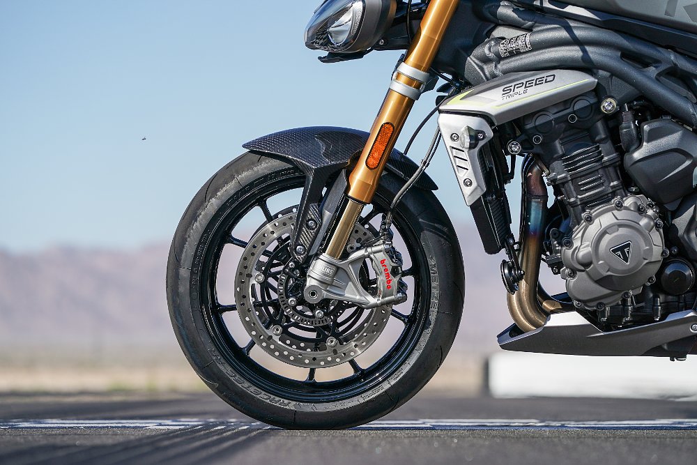 A close up of the front tire on the Triumph Speed Triple 1200 RS showing off the Brembo brake rotor and calipers.