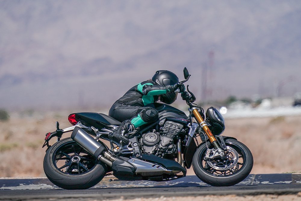 female rider in a sport tuck position on board the Triumph Speed Triple 1200 RS.