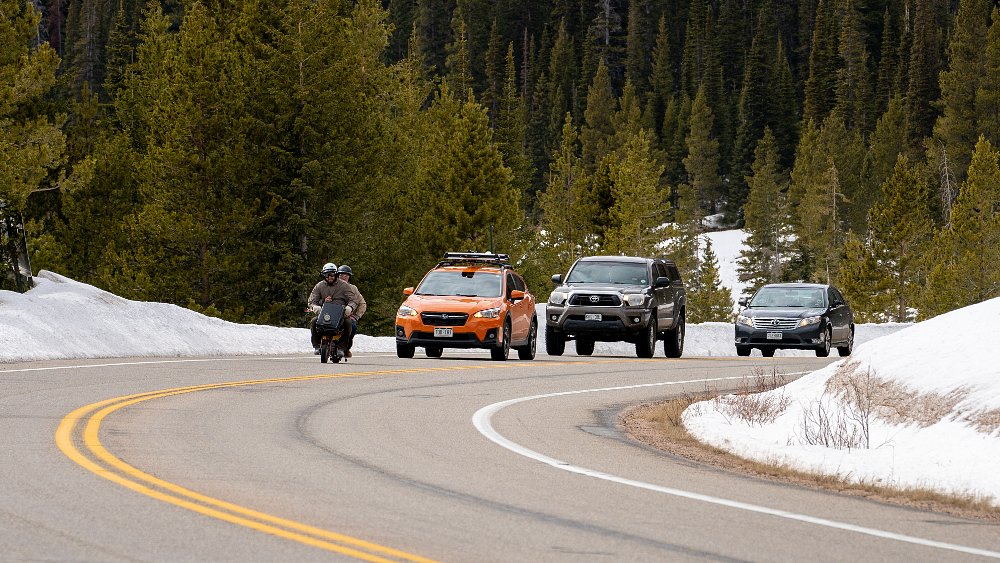 A slow-moving mini bike holding up traffic on a mountain road