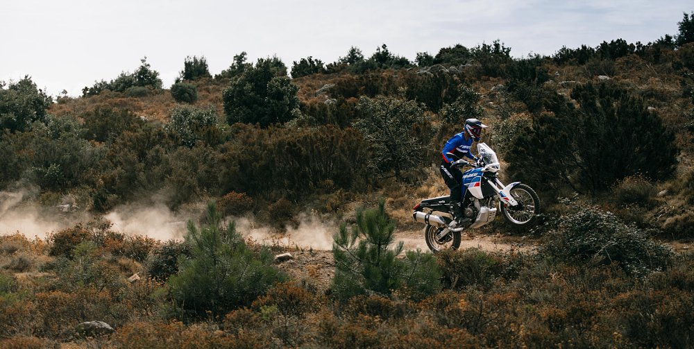 Aprilia Tuareg doing a wheelie on a dirt road